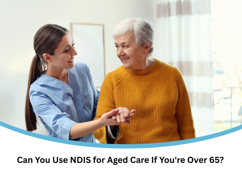 Young female carer supporting a smiling elderly woman at home, representing support options under NDIS over 65 for aged care needs.