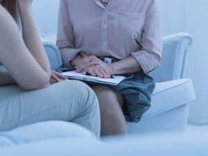 Health provider assist NDIS participants through a counselling session in a supportive, seated setting.
